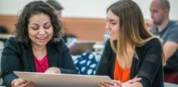 two students looking at posterboard together