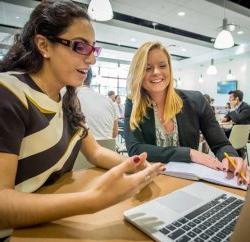 two entrepreneural students collaborating on a project with a laptop